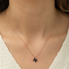 Necklace with a butterfly pendant worn by a person