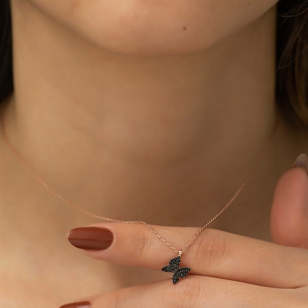 Rose gold necklace with a butterfly pendant on a blurred background