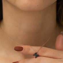 Rose gold necklace with a butterfly pendant on a blurred background