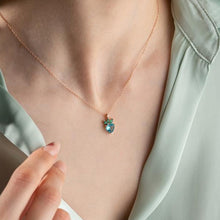 Necklace with a green pendant worn by a person, against a light background