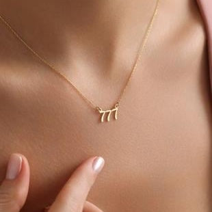 Gold necklace with a small pendant on a person's neck