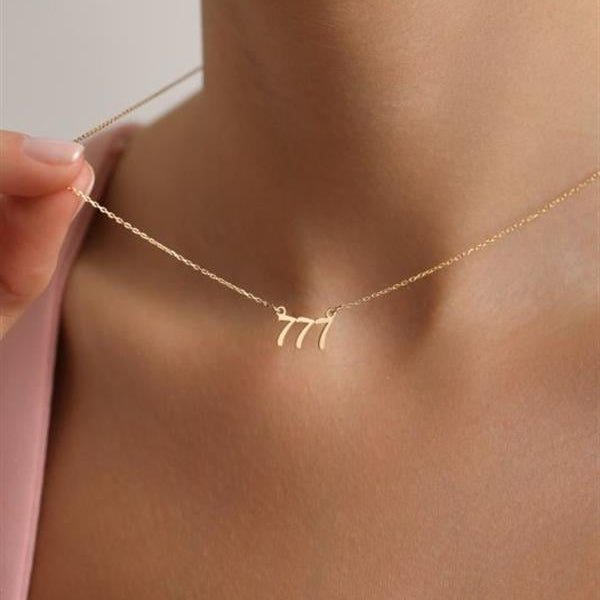 Gold necklace with leaf design worn by a person