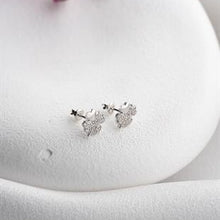 Silver earrings with clear stones on a white jewelry display