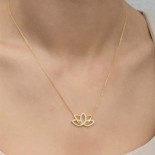 Gold necklace with a lotus flower pendant on a neutral background