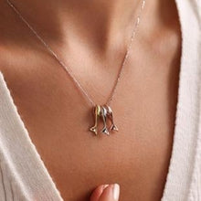 Necklace with a unique pendant on a person wearing a white top.