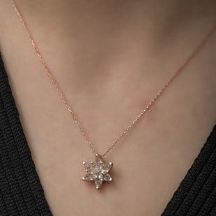 Rose gold necklace with a star-shaped pendant on a person wearing a black top.