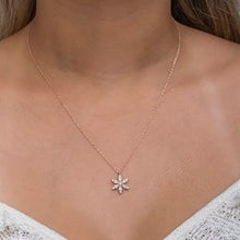Necklace with a delicate flower pendant on a person's neck