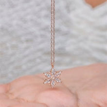Rose gold snowflake pendant necklace on a blurred background