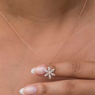 Rose gold necklace with a diamond pendant on a blurred background