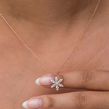 Rose gold necklace with a diamond pendant on a blurred background