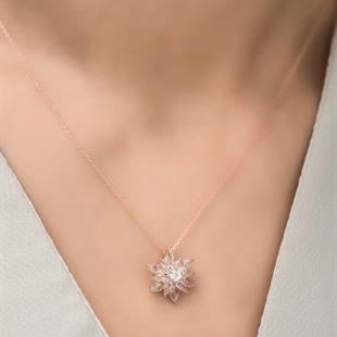 Rose gold necklace with a star-shaped pendant on a neutral background