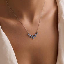 Necklace with blue gemstones worn by a person, focusing on the necklace.