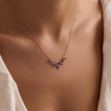 Necklace with blue stones on a person wearing a white blouse