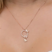 Rose gold necklace with butterfly pendant on a person's neck