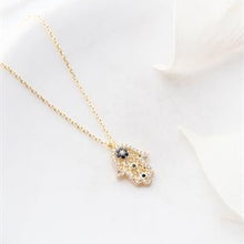 Gold necklace with a small pendant on a white background