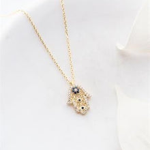 Gold necklace with a decorative pendant on a white background