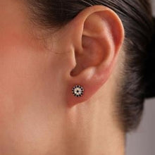 Close-up of an ear wearing a stud earring with a blurred background