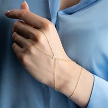 Gold bracelet on a hand with a blurred blue background