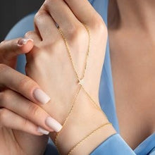 Close-up of hands wearing gold necklaces against a blue background