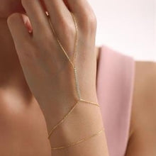 Close-up of a hand wearing a gold bracelet on a blurred background