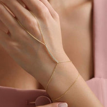 Gold anklet on a person's ankle with a soft pink background
