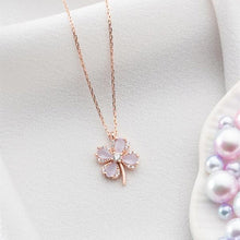 Rose gold necklace with a clover-shaped pendant on a light background
