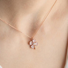 Rose gold necklace with a floral pendant on a person's neck