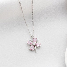 Pink four-leaf clover pendant on a silver chain against a light gray background