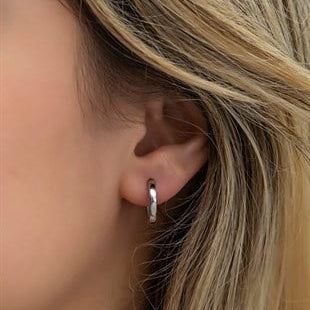 Close-up of a person wearing a silver hoop earring.