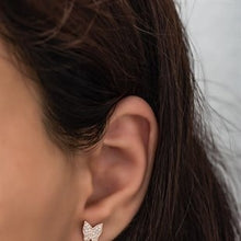 Close-up of an ear wearing a diamond earring with a blurred background