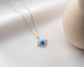 A sterling silver astrology-themed necklace photographed under soft lighting for an elegant glow.