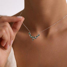 Necklace with green gemstones being worn on a person's neck