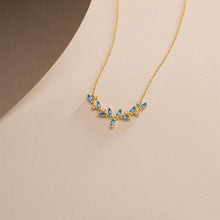 Gold necklace with blue stones on a beige background