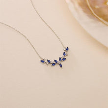 Necklace with blue gemstone leaves on a beige background