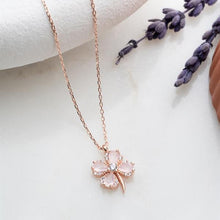 Rose gold necklace with a pink floral pendant on a white background