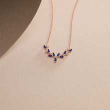 Rose gold necklace with blue stones on a beige background