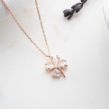 Rose gold necklace with a diamond pendant on a light background