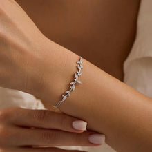 Silver bracelet on a wrist with a neutral background