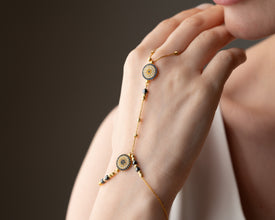 Stacked evil eye bracelets in gold and cobalt blue for layered protection