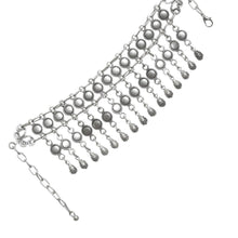 Silver bracelet with dangling beads on a white background