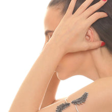 Woman wearing a silver feather earring on a white background