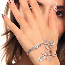 Silver leaf bracelet on a person's wrist with a neutral background
