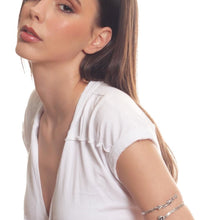 Woman wearing a white top on a plain background