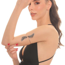 Woman with a feather tattoo on her arm against a white background
