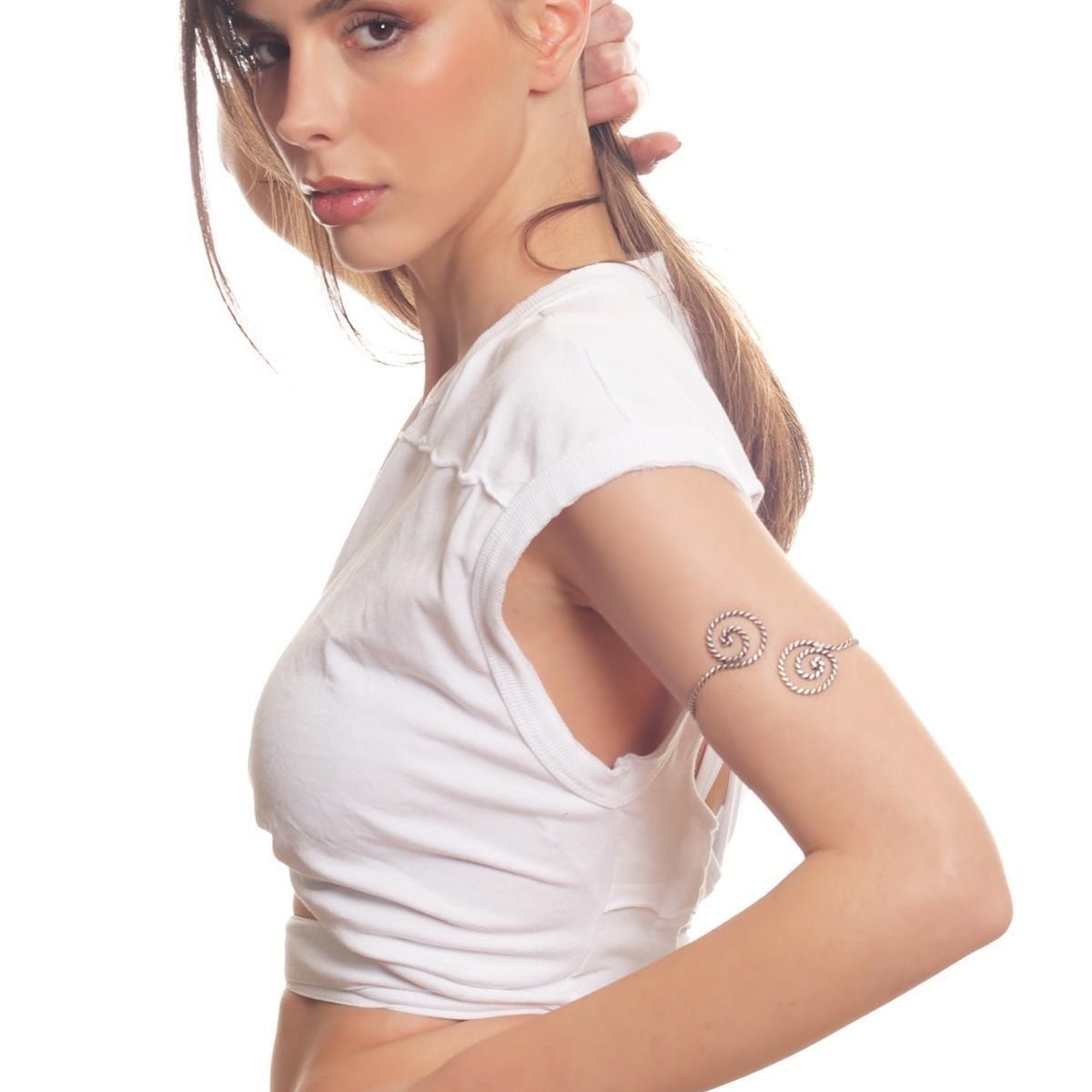 Woman wearing temporary tattoos on her arm against a white background