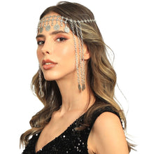 Woman wearing a silver chain headpiece with dangling elements on a white background