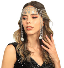 Woman wearing a decorative headpiece with chains and coins on a white background
