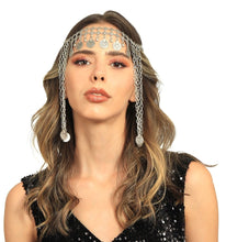 Woman wearing a silver chain headpiece on a white background