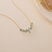 Gold necklace with blue stones on a beige background