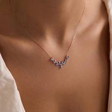 Necklace with blue stones worn by a person, focusing on the jewelry.